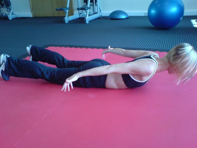 image shows: Sharpbodies Personal Training Vikki doing prone cobra, the corrective exercise for a bend pattern movement